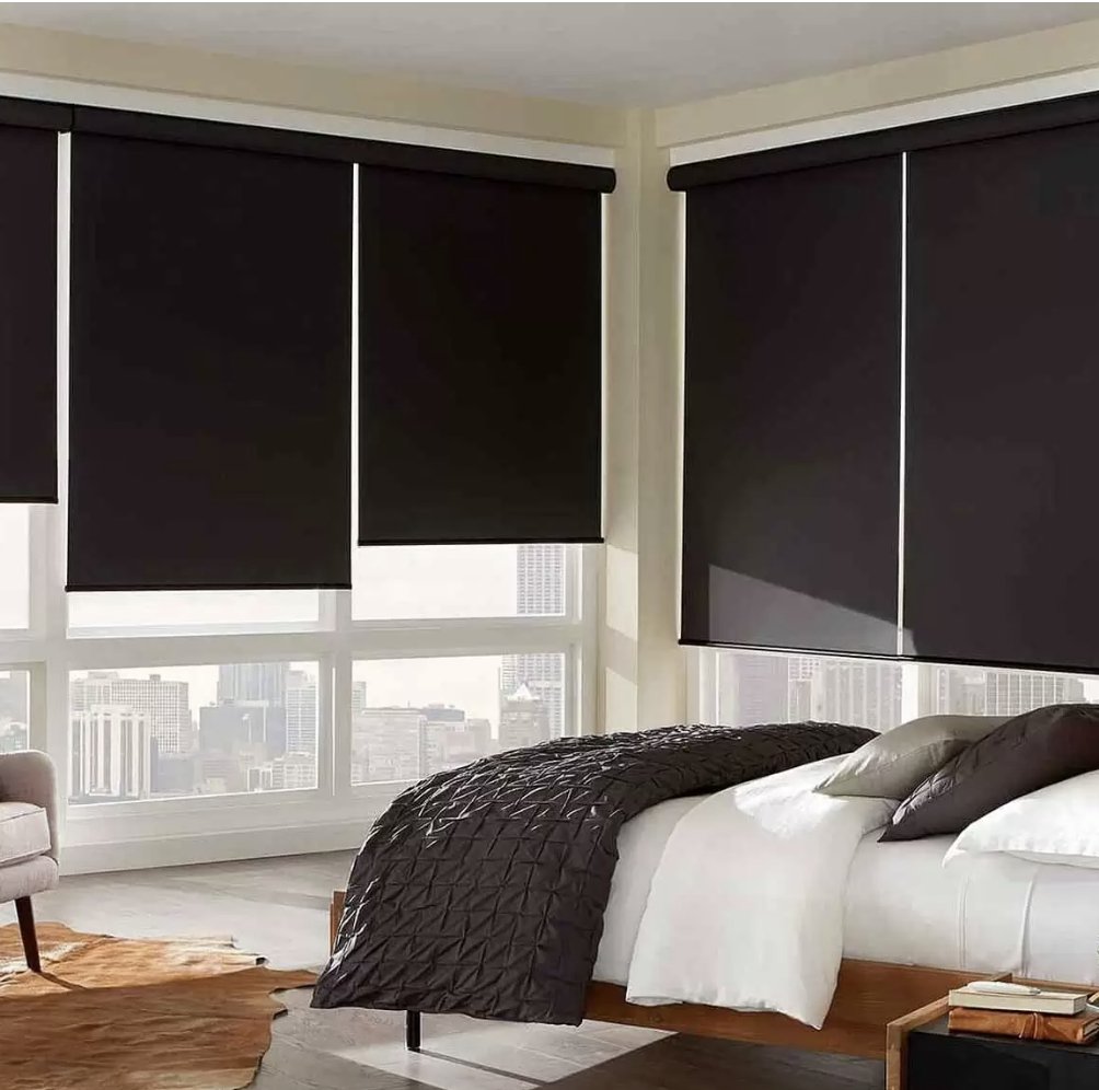 dark blackout roller shades in a bedroom